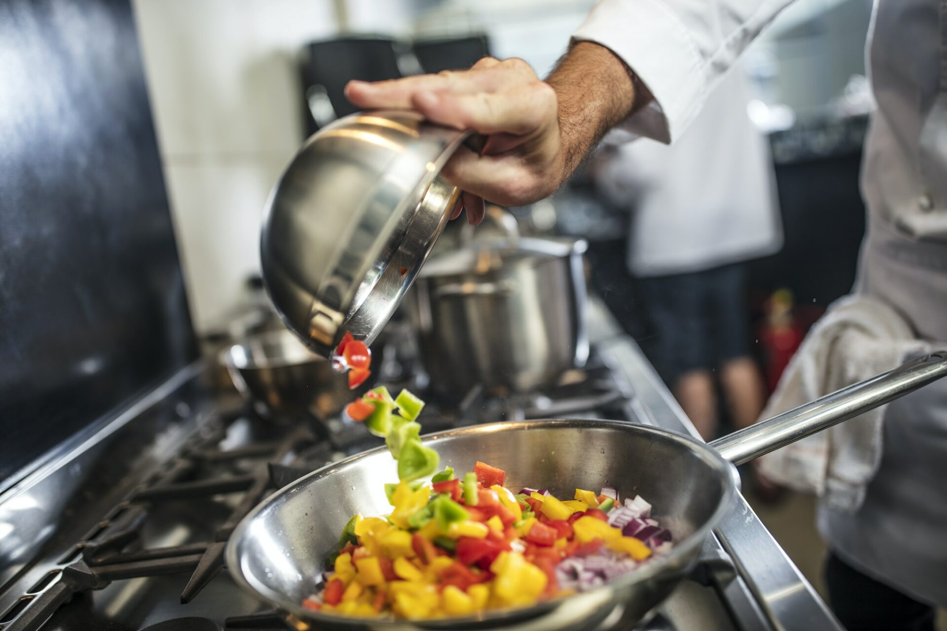 Colorful vegetables cooking in a pan on a stovetop at Le Gourmet Factory